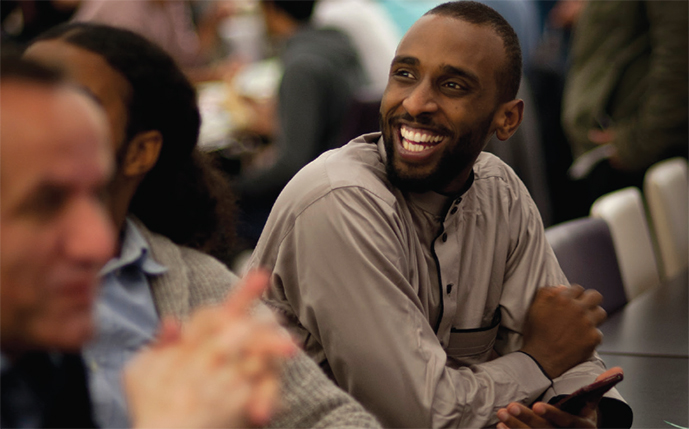 Masters students sit at a table talking to each other at a cafe at the University of Sussex