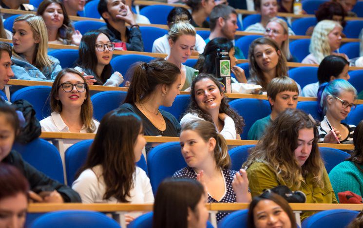 Lots of students in a lecture theatre chatting