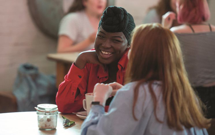 two students chatting over a coffee in a cafe