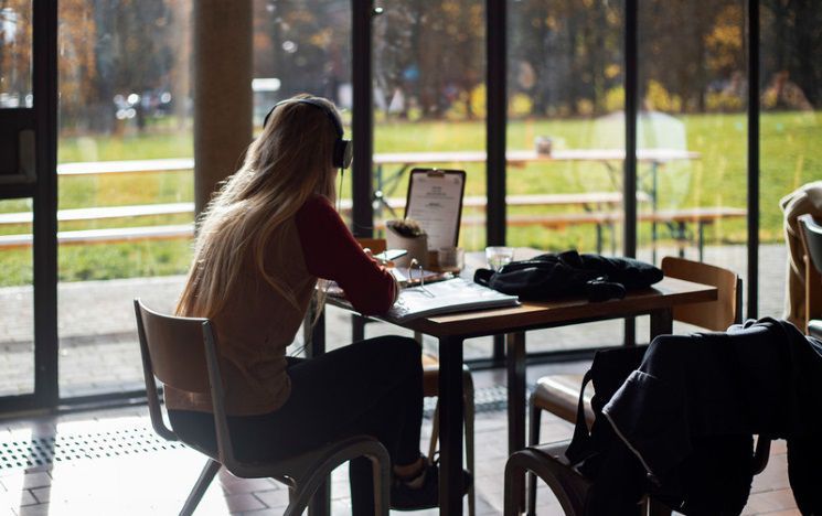 Student sitting in ACCA cafe on laptop