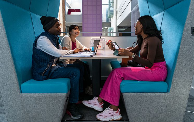 A group of students smiling in a study booth