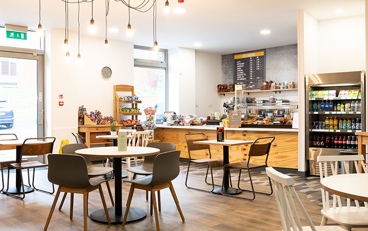 The counter and seating area with confectionary on the counter and nice lighting