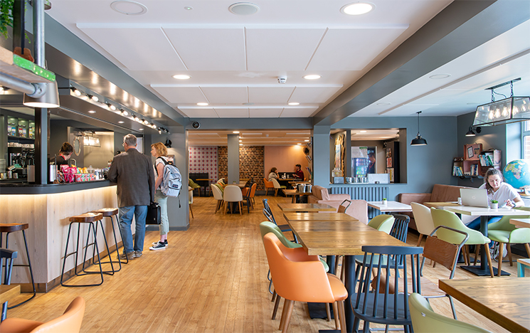 The counter and seating area with confectionary on the counter and nice lighting