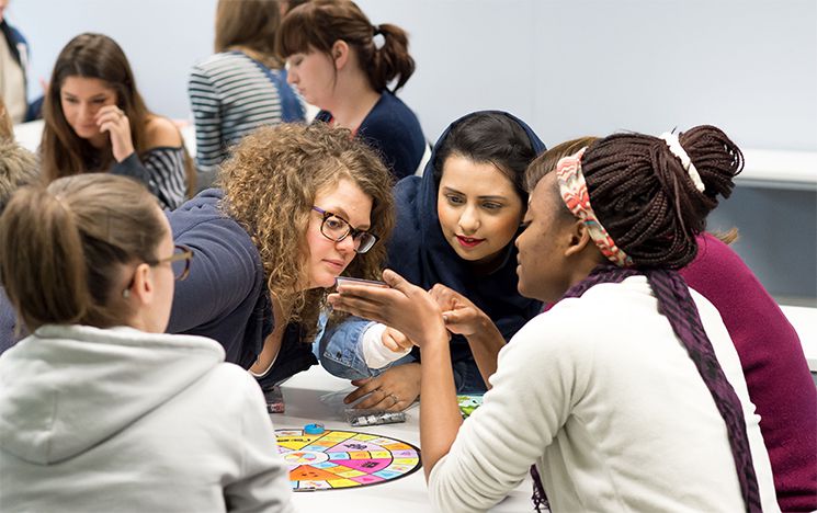 A group of trainee teachers gathered round a table in a creative workshop.